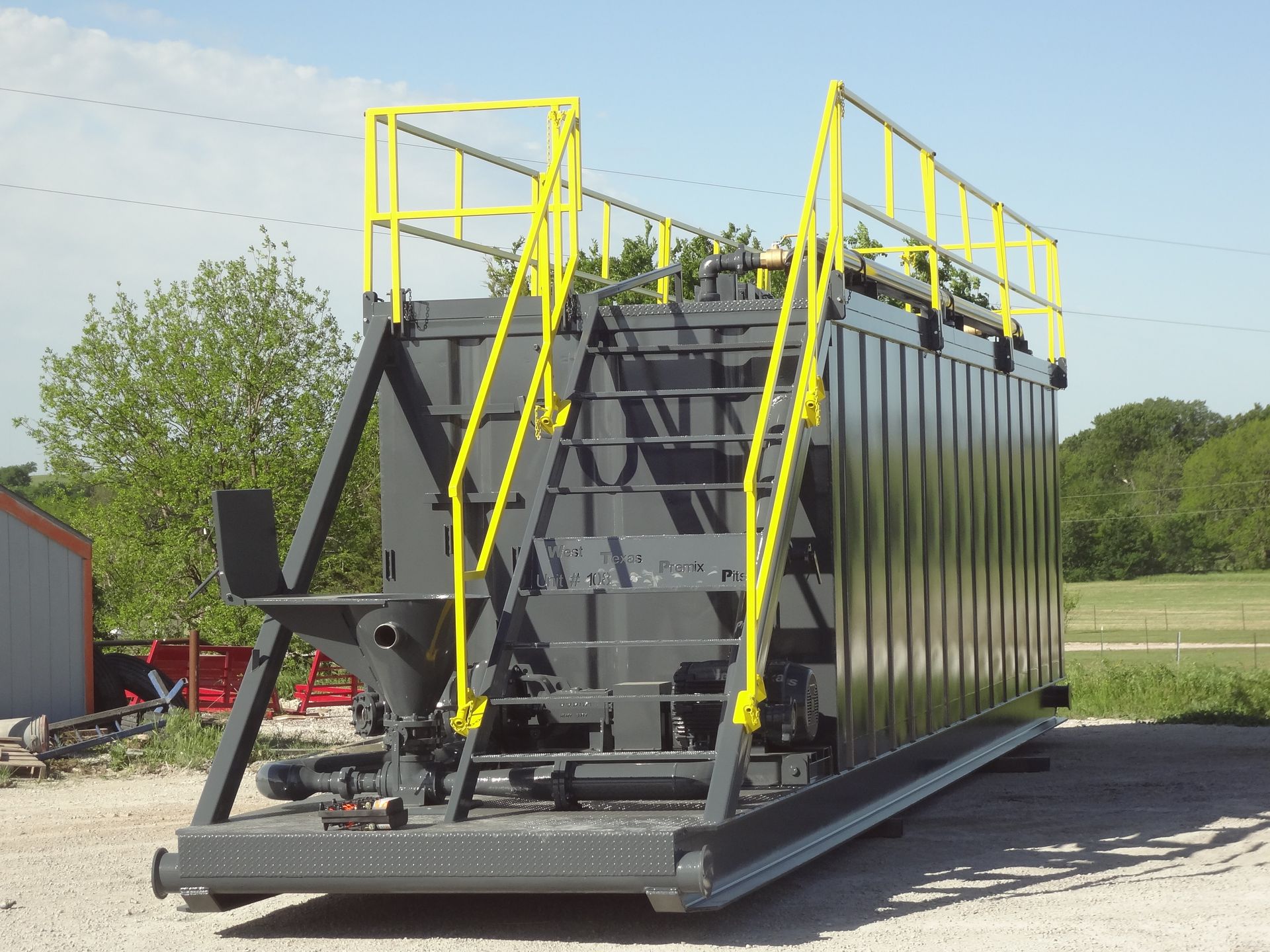 A large black container with a yellow railing and stairs