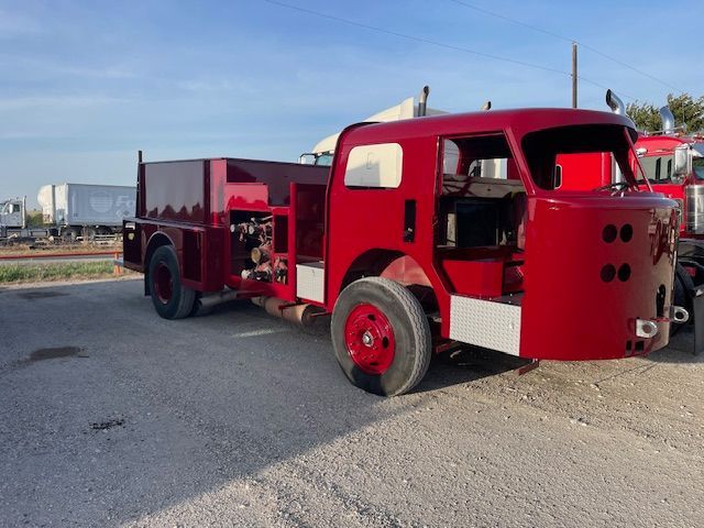A red truck is parked on the side of the road