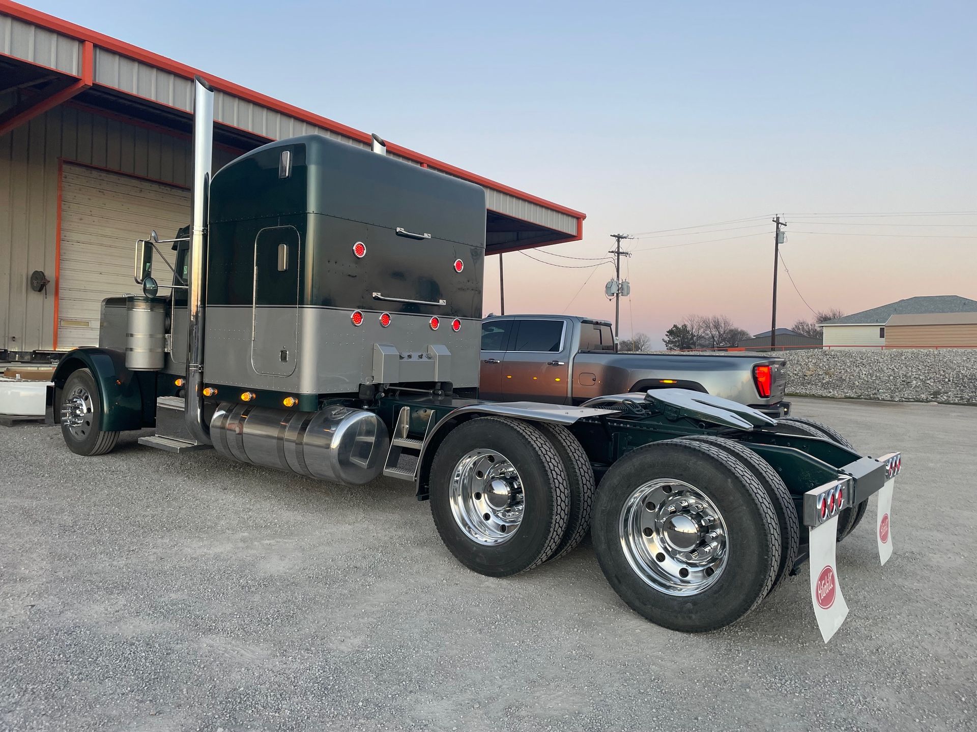 A semi truck is parked in front of a building.
