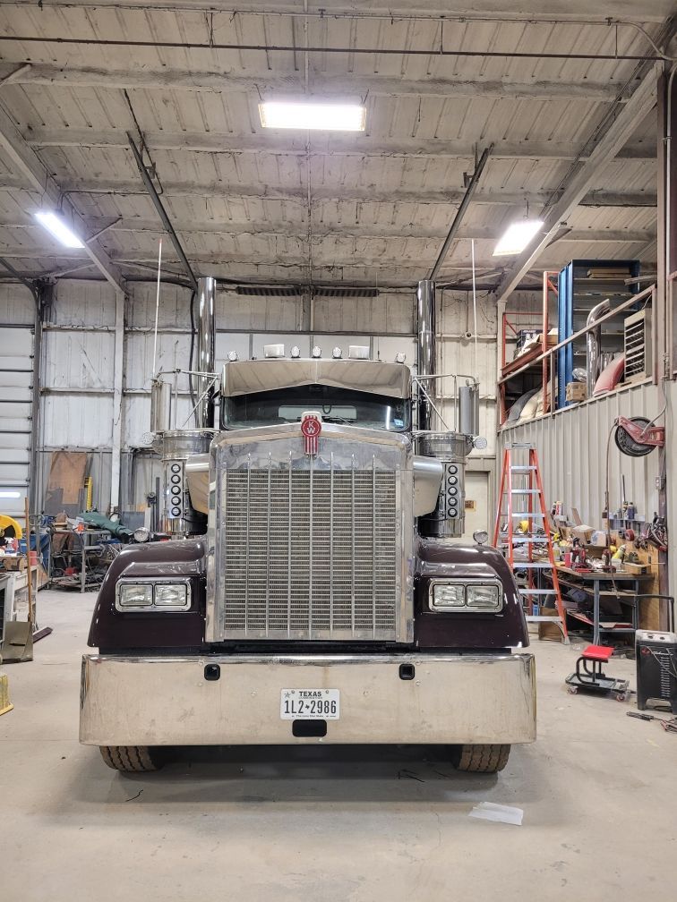 A large semi truck is parked in a garage.
