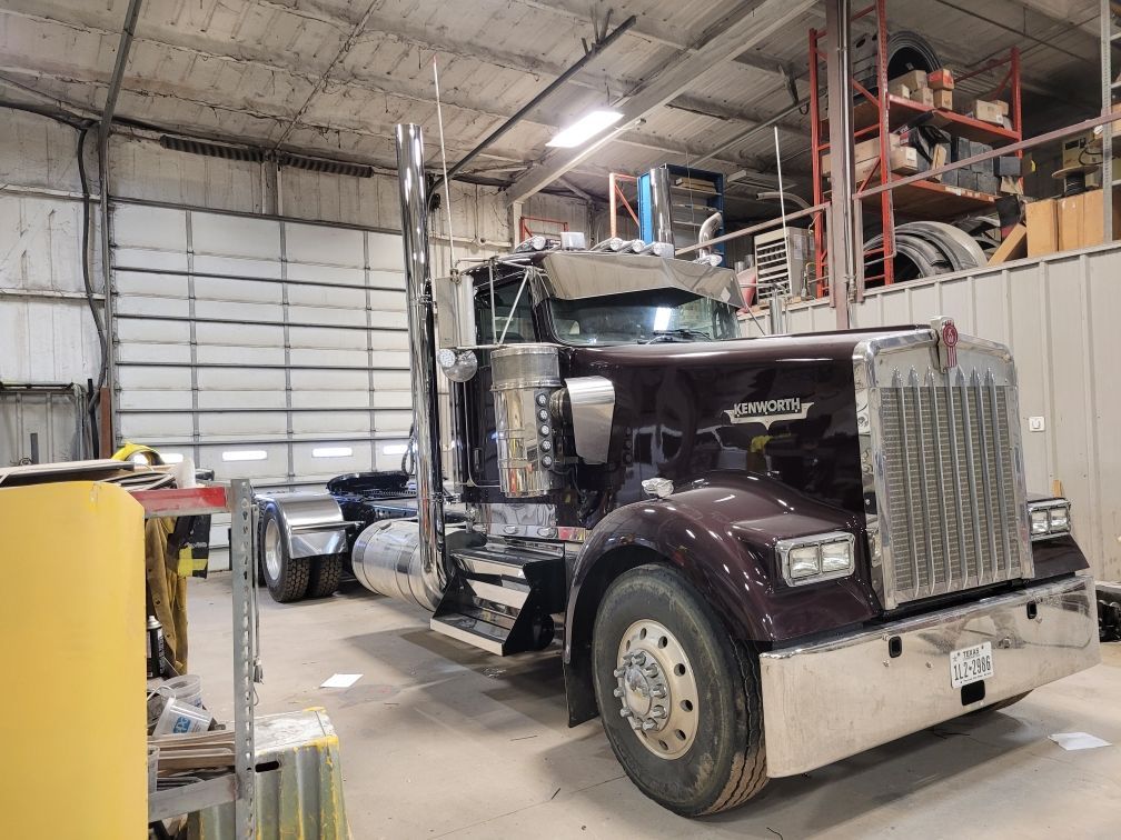 A large semi truck is parked in a garage.