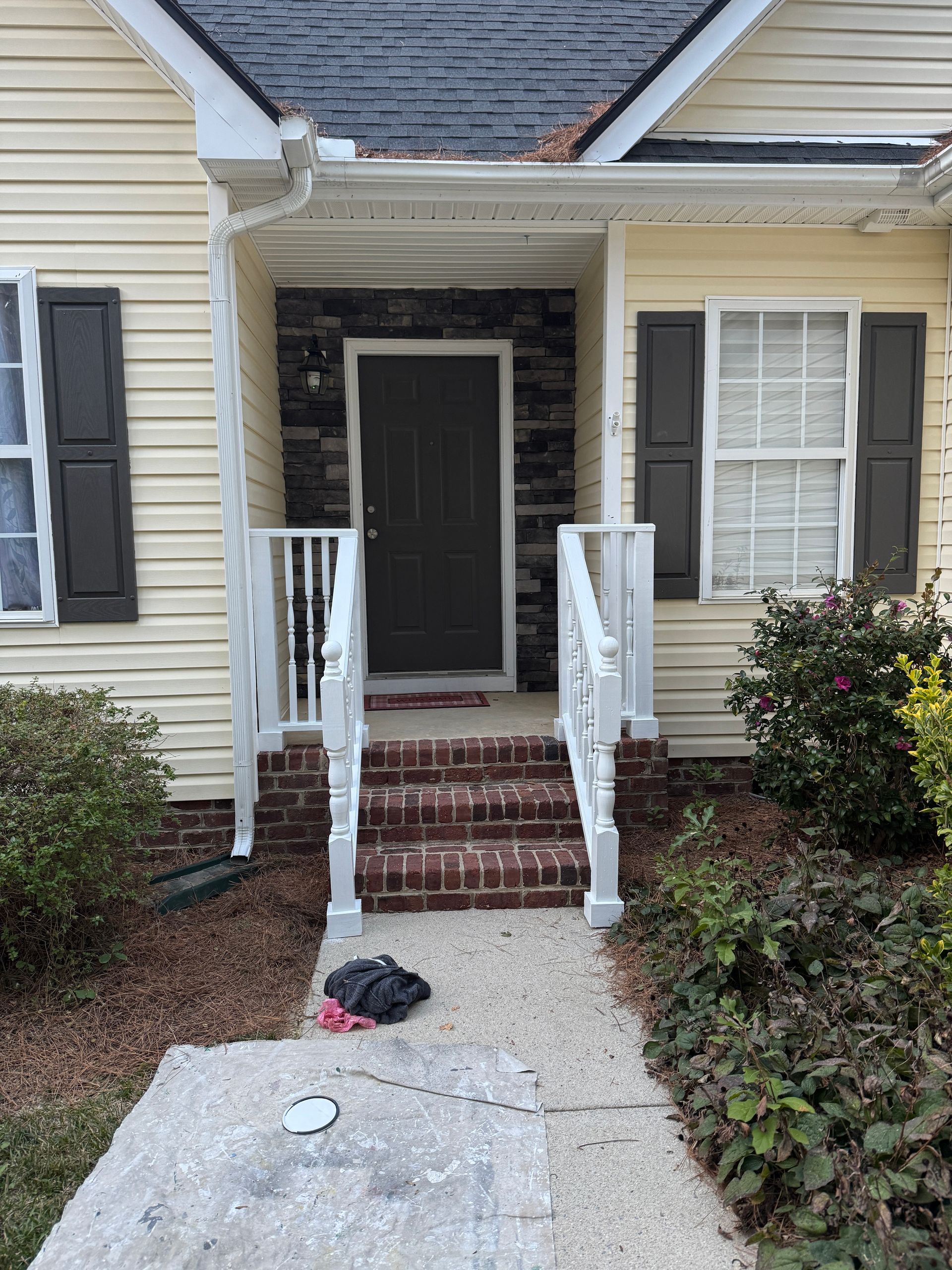 Exterior of a house with a front door, brick steps, and a pathway leading to it