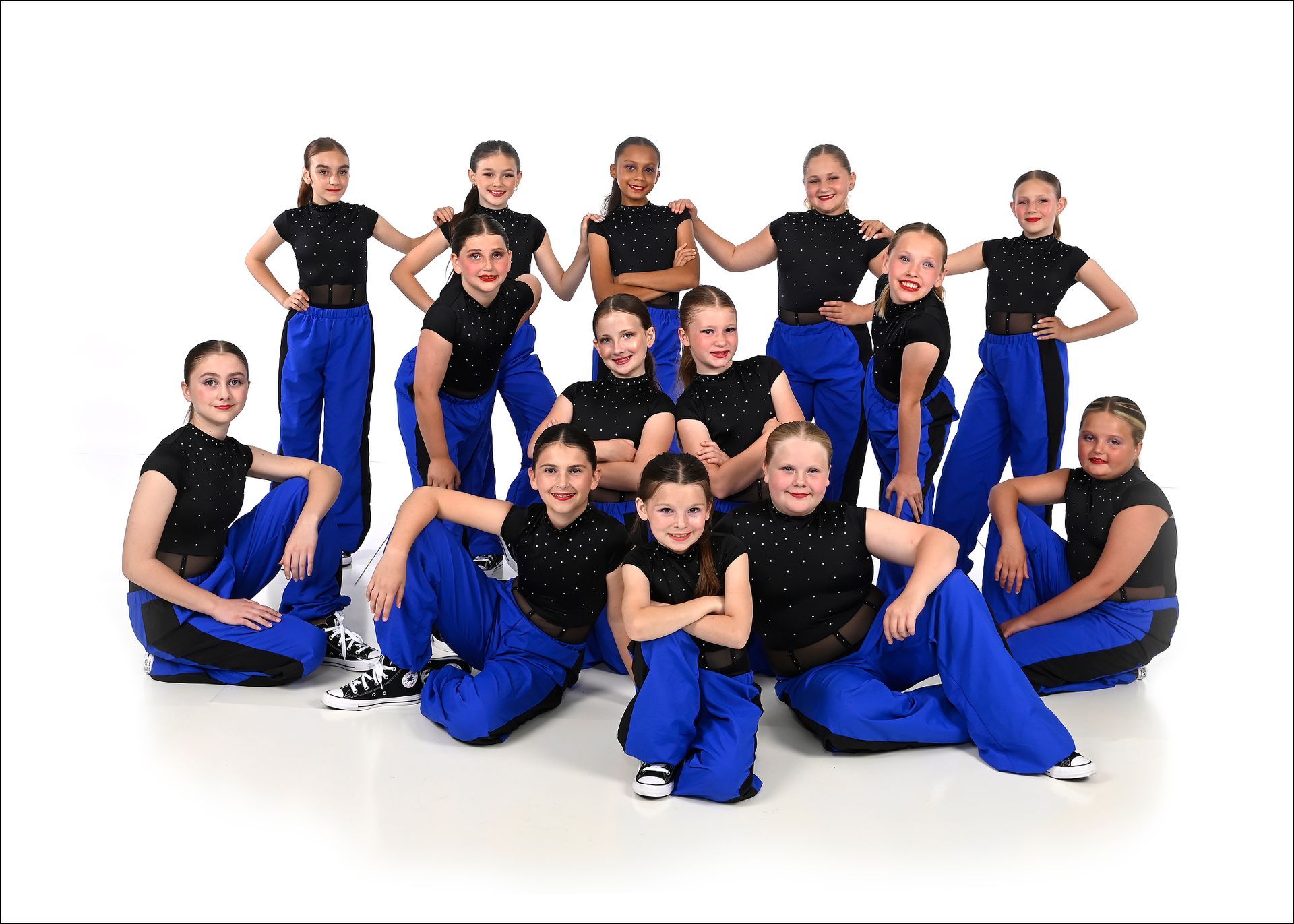 A group of young girls in purple outfits are posing for a picture.