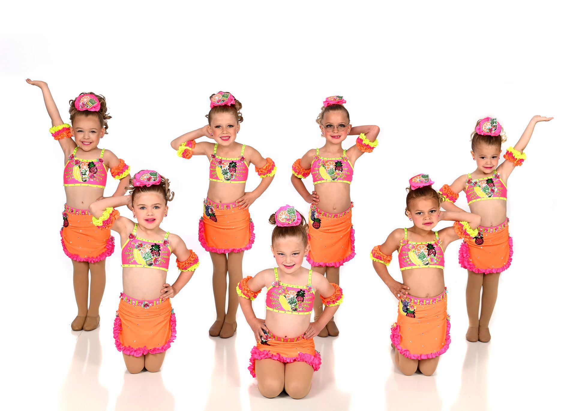 A group of young girls in blue and yellow costumes are posing for a picture.