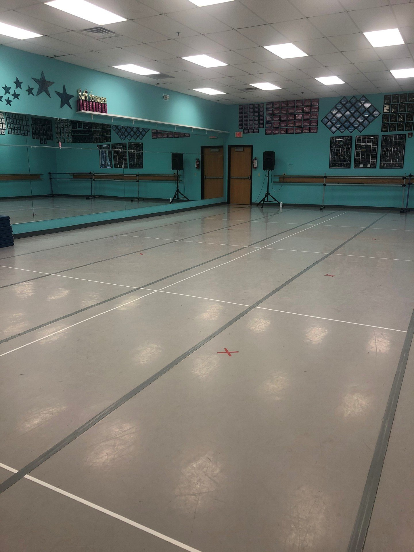 A large empty dance studio with a lot of mirrors.