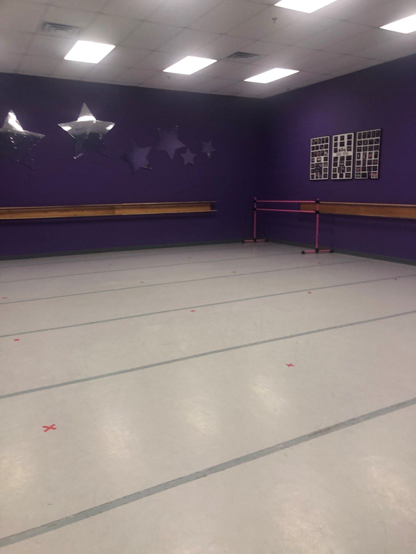 An empty dance studio with purple walls and a white floor