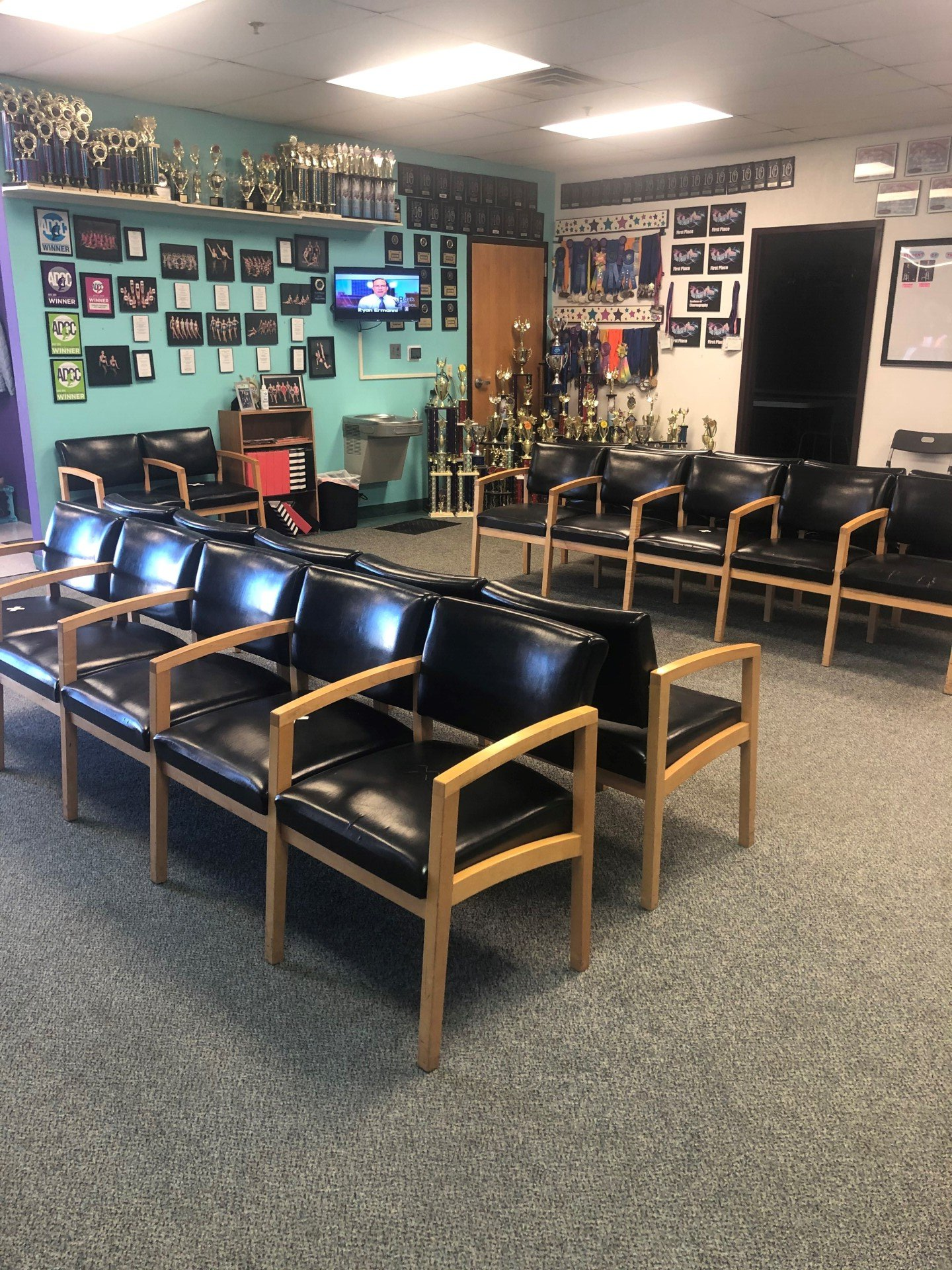 A room with a lot of chairs and trophies on the wall