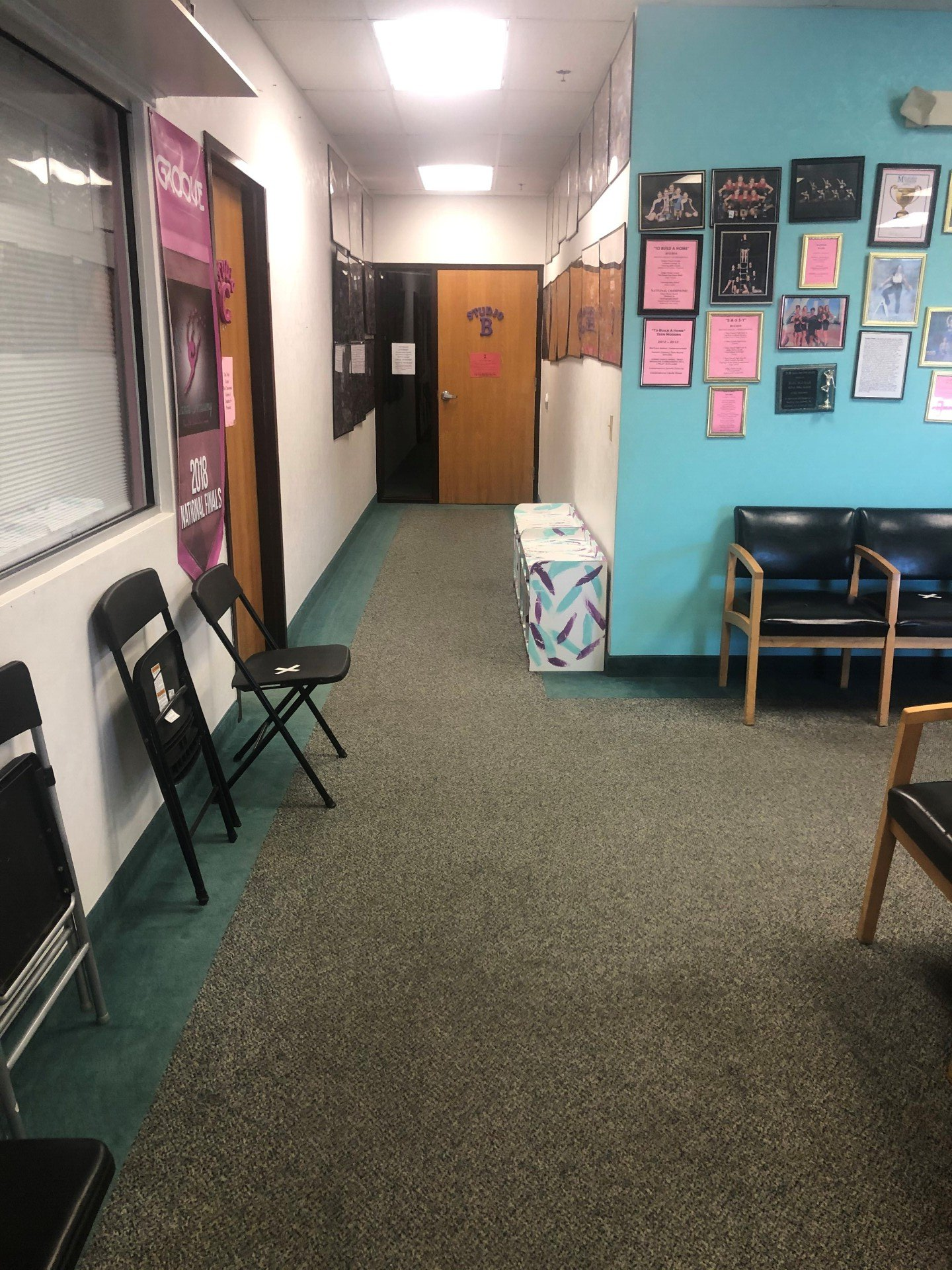 A long hallway with chairs and a sign on the wall.