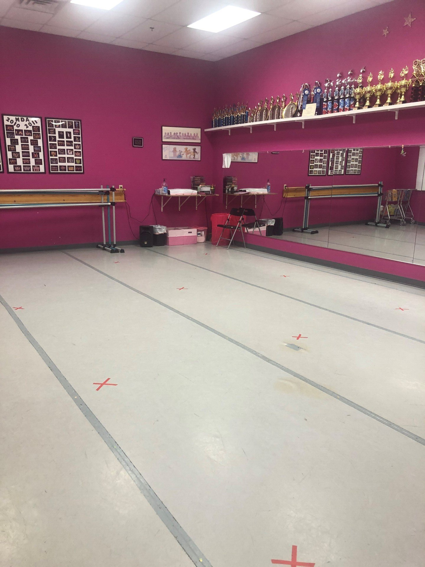 A dance studio with pink walls and a large mirror.