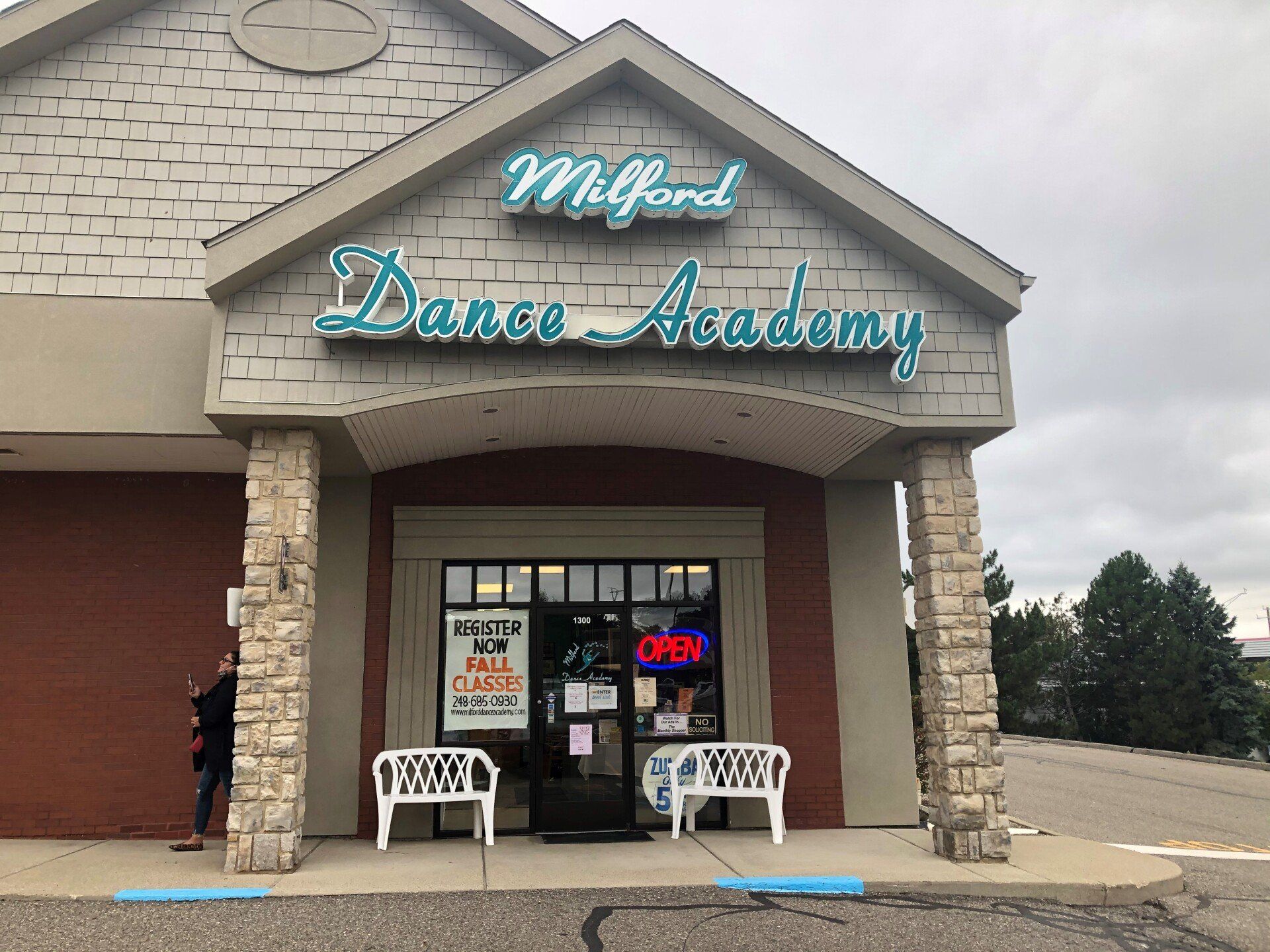A man is standing in front of a dance academy building.
