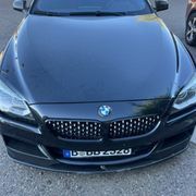 Black BMW car, front view, with license plate visible.