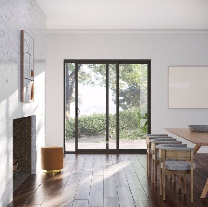 Modern dining room with sliding glass doors, wood table, stools, and sunlight streaming onto the floor