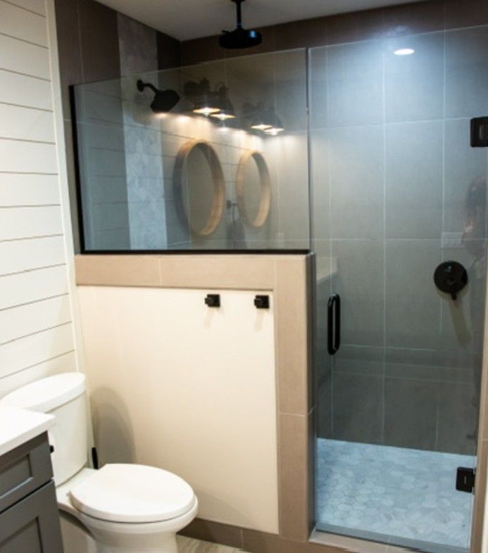 Modern bathroom with toilet, glass shower, and tiled walls