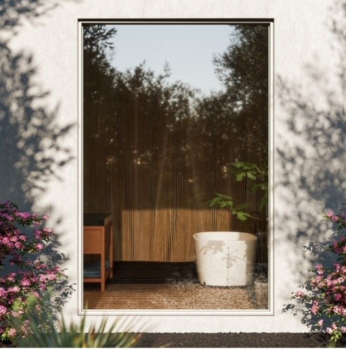 Window view of a small patio with a wooden screen, white planter, and leafy potted plant beside a chair
