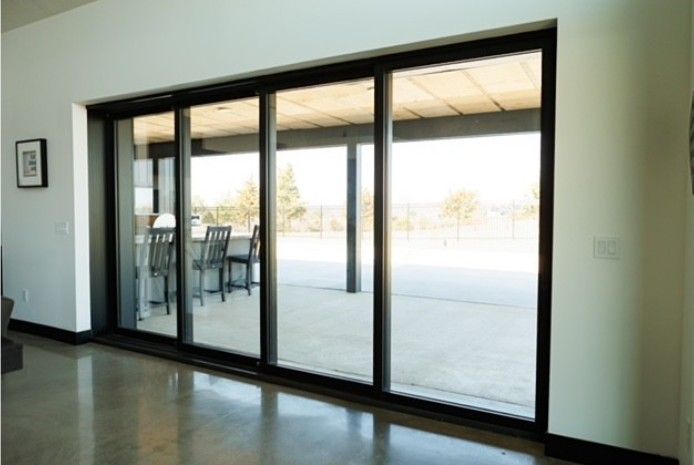 Glass sliding doors opening to a bright patio or outdoor deck area