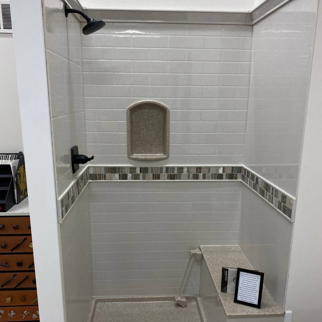 A shower with a built-in seat, a built-in soap niche, and tile surround.