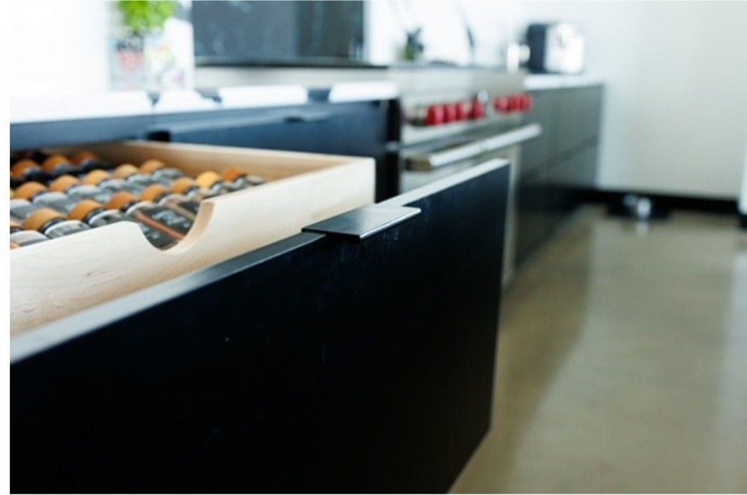 Open kitchen counter with trays of baked goods in black and white cabinets