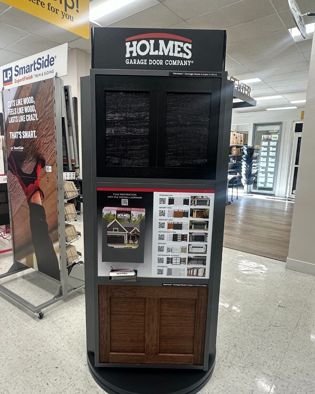Holmes door display in a store, showcasing door samples and brochures.