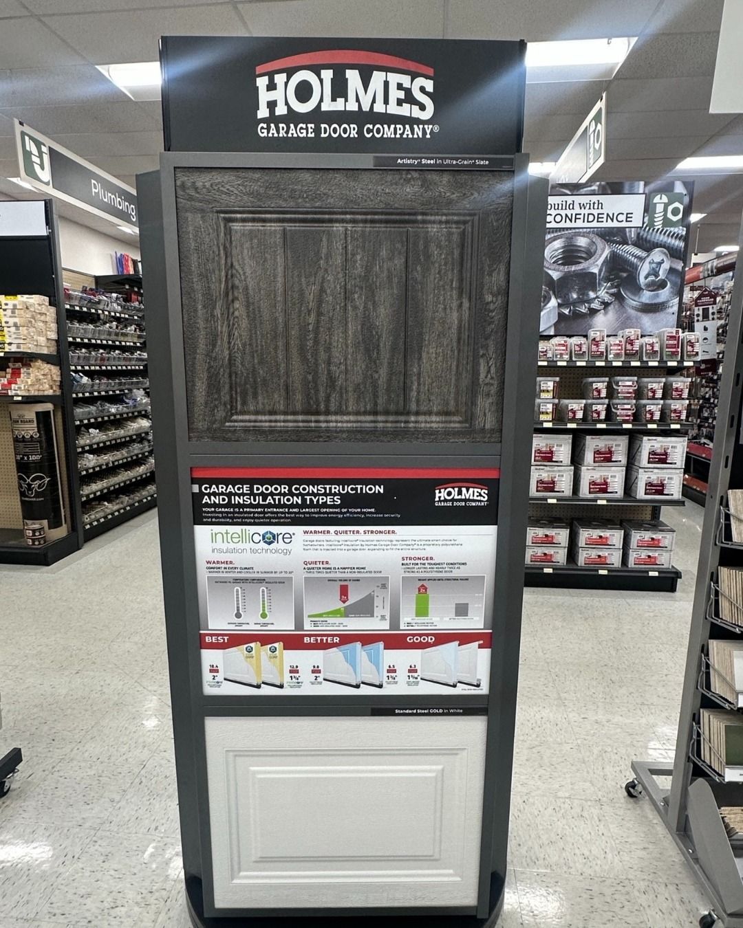 Display showcasing Holmes cabinet door samples in a store. Includes top dark wood and lower white door sections with informative graphics.