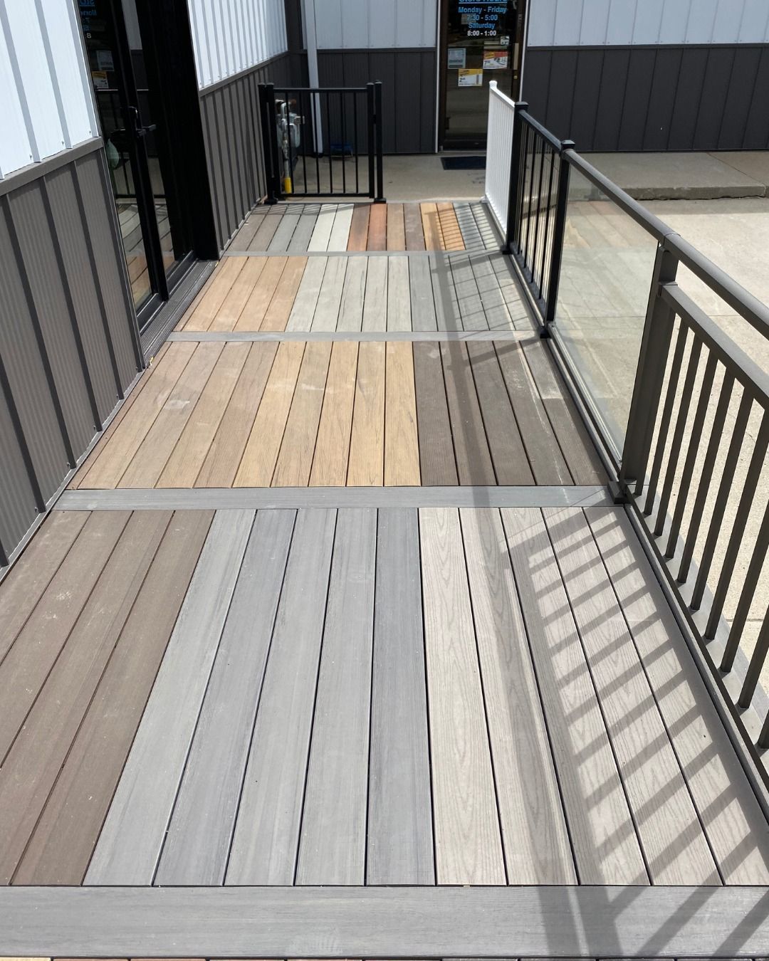 Wooden ramp with various colored planks, metal railings and accents leading to a building entrance.