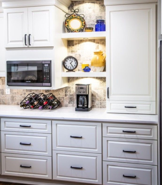 White kitchen with built-in microwave, coffee maker, shelves, and gray cabinets