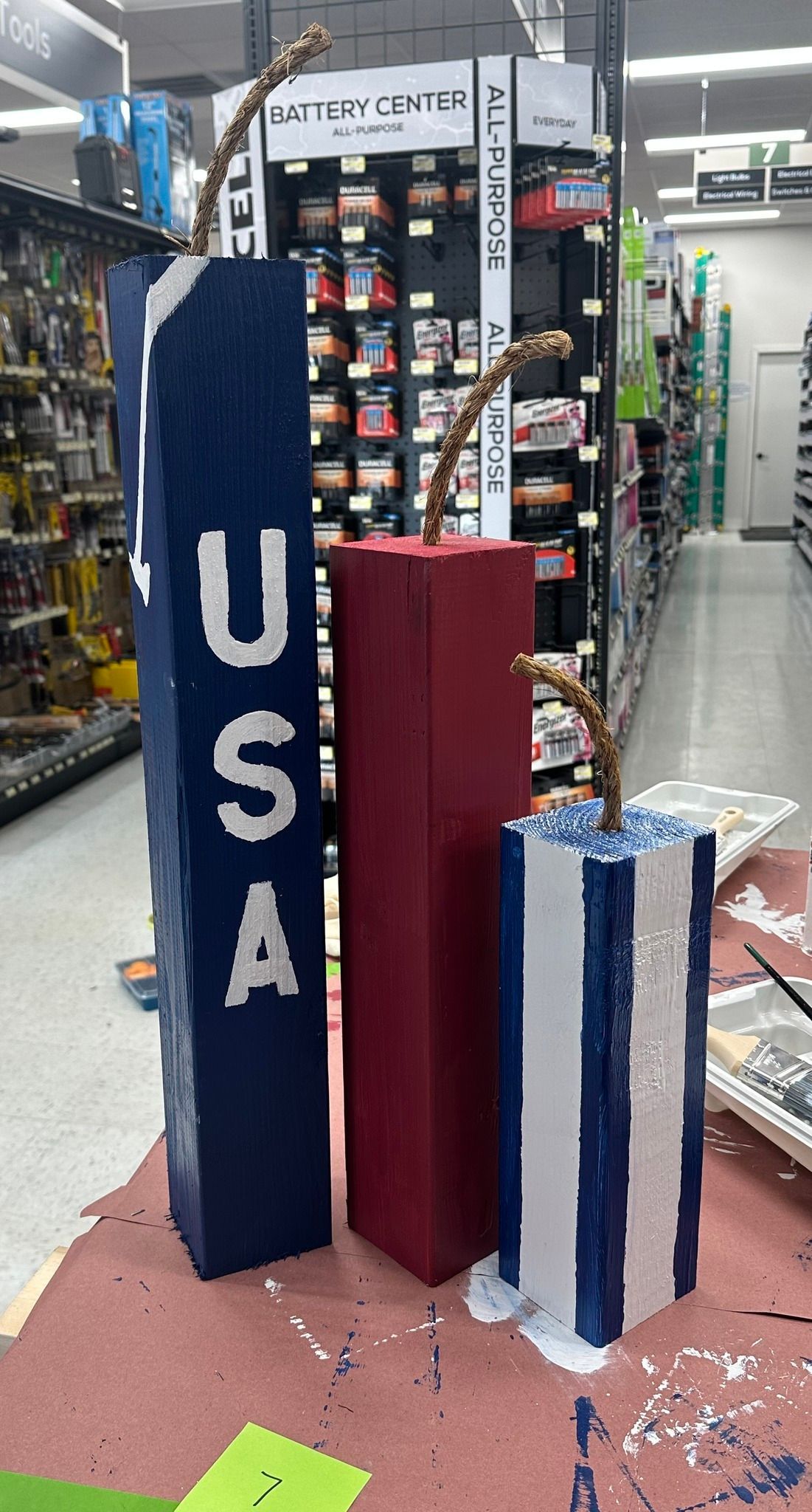 Three decorative wooden firecrackers in red, white, and blue; 