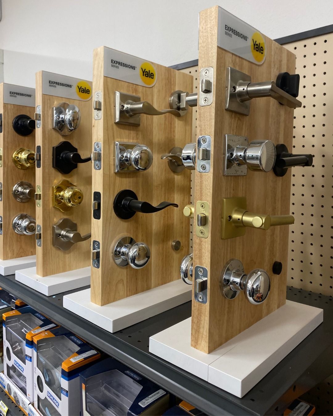 Display of door handles on wooden boards in a hardware store.