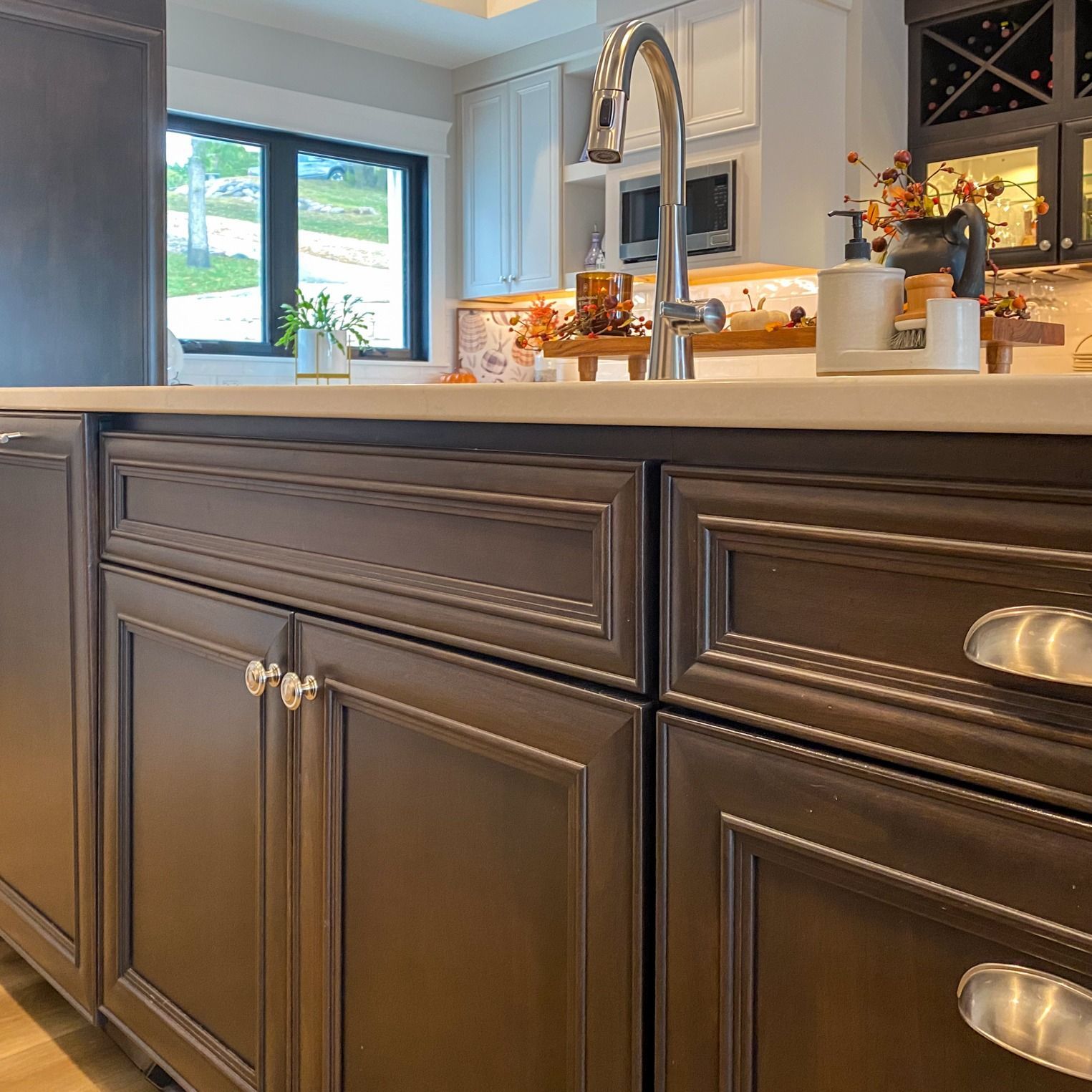 Dark brown kitchen cabinets with silver hardware and a white countertop.