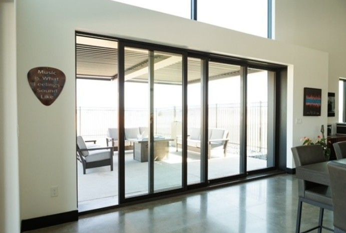 Modern interior with sliding glass doors opening to a bright patio seating area