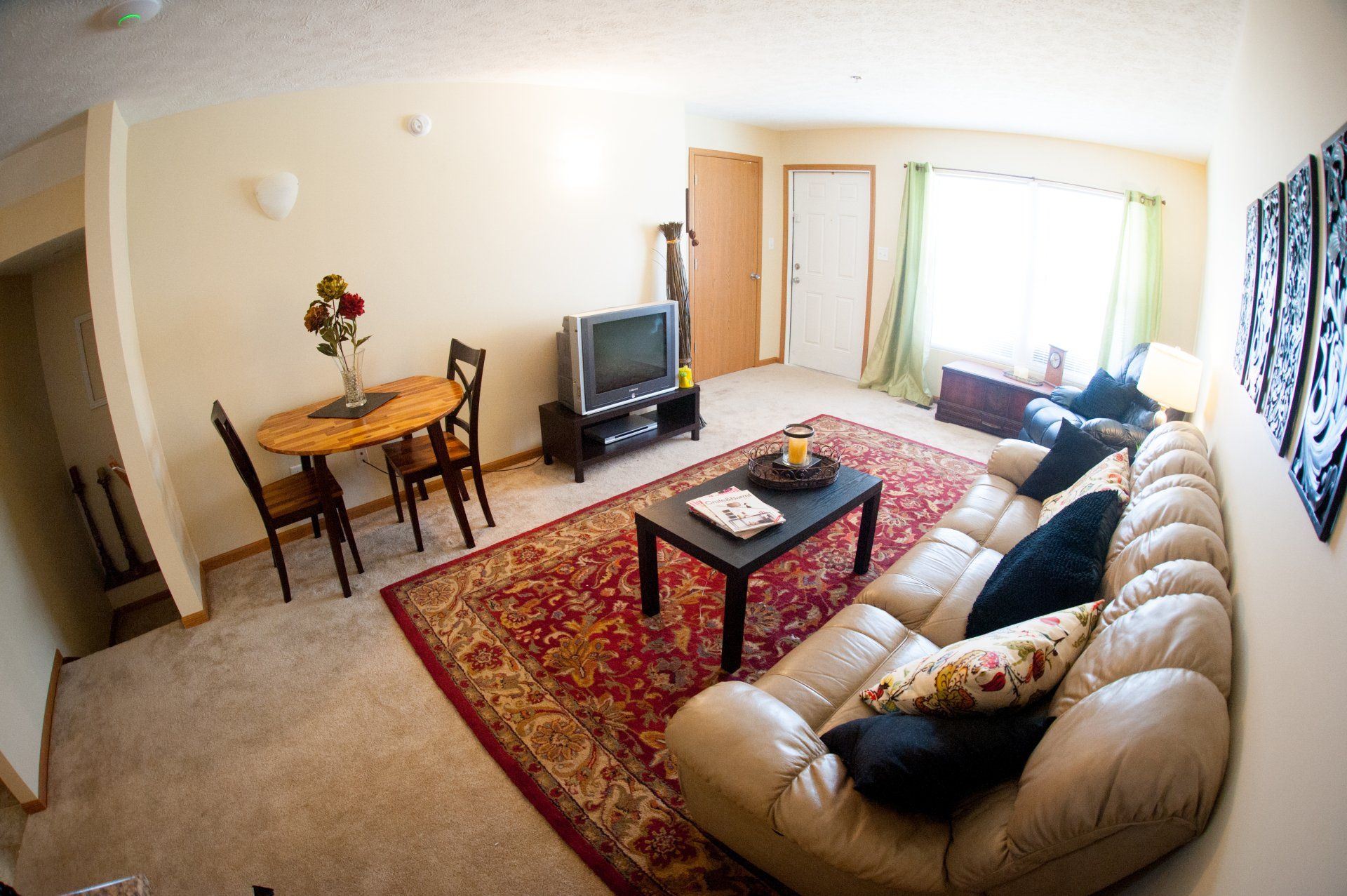 A living room with a couch a table and a television.