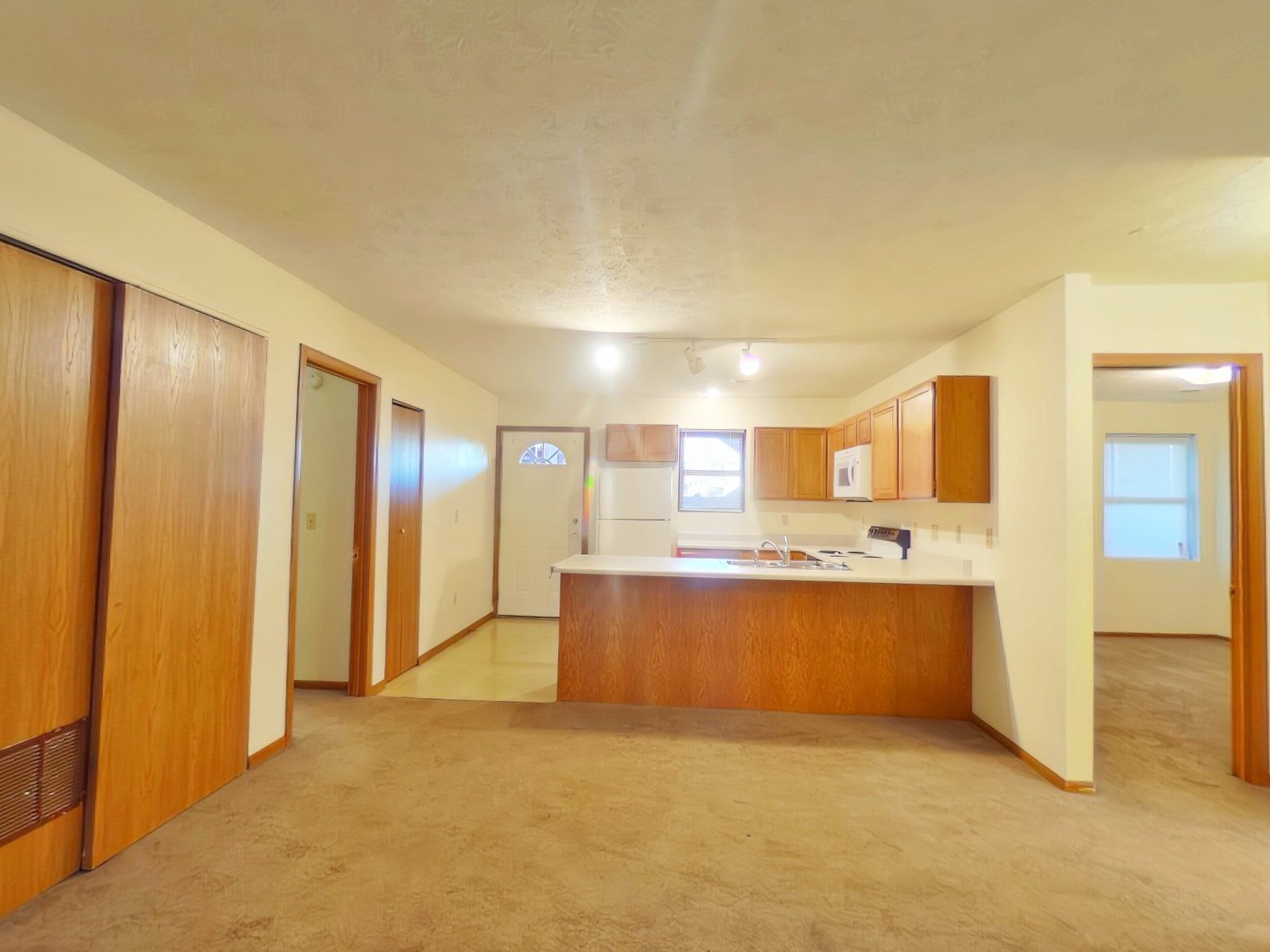 An empty house with a kitchen and a living room.