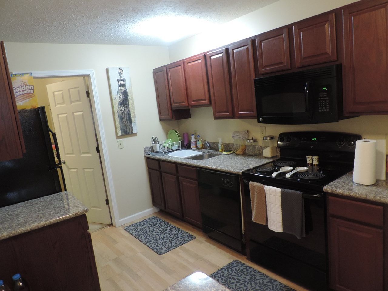 A kitchen with wooden cabinets and granite counter tops.