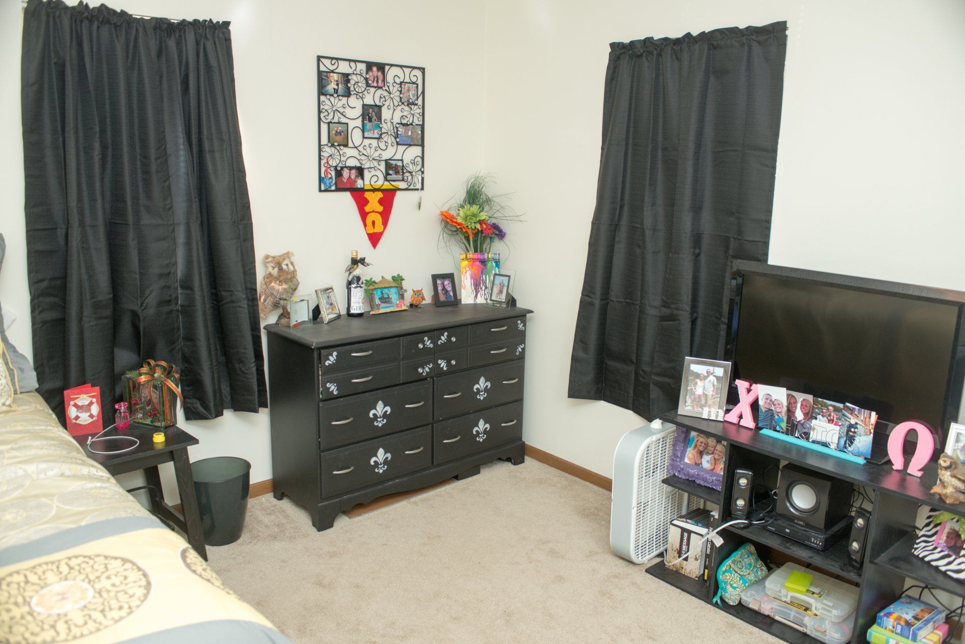 A bedroom with a dresser and a flat screen TV.