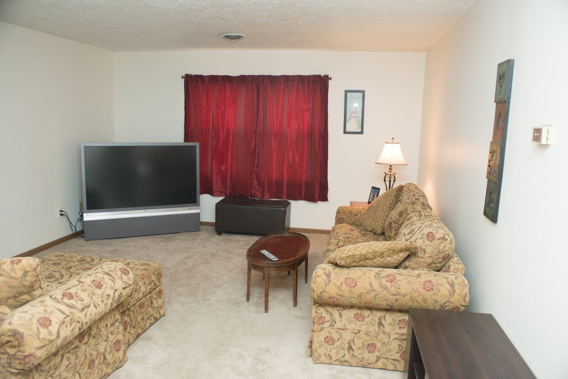 A living room with two couches and a flat screen TV.