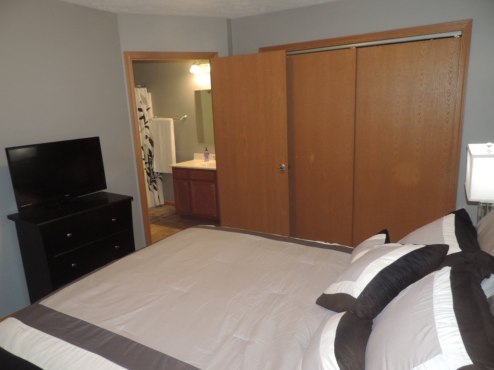 A bedroom with a king size bed and a flat screen TV.