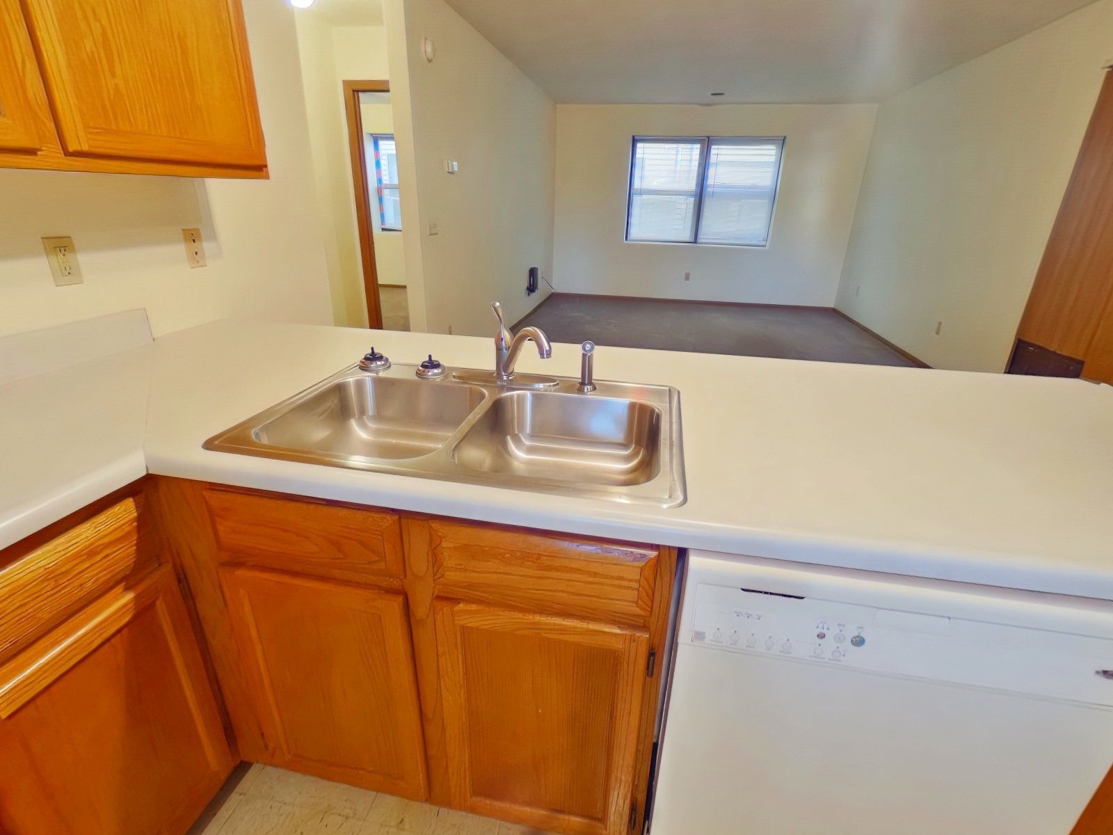 A kitchen with two sinks and a dishwasher.