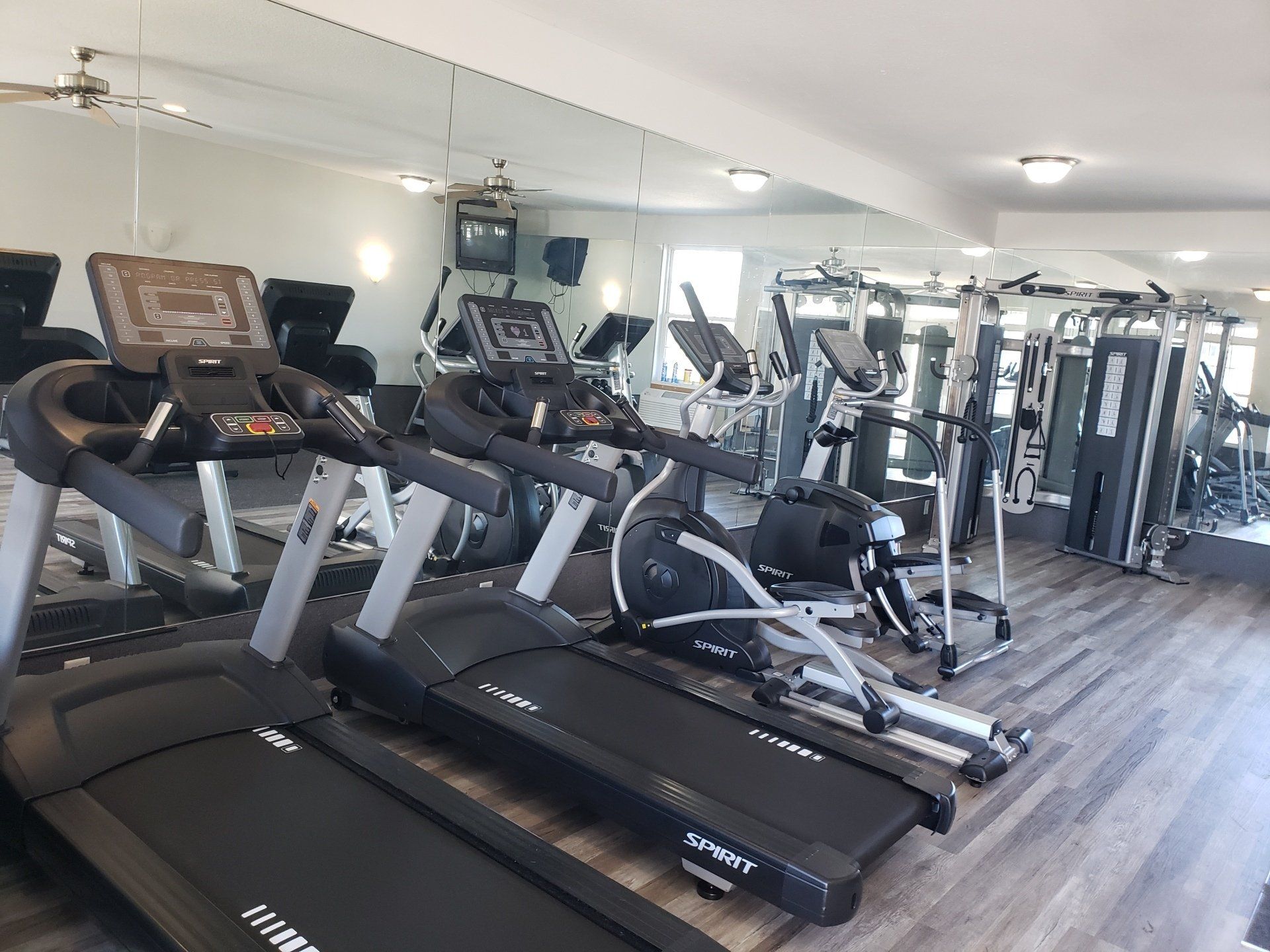 A gym filled with treadmills, ellipticals, and other exercise equipment.