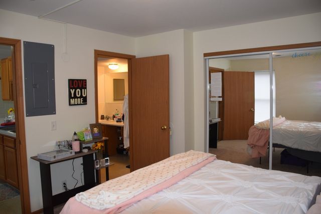 A bedroom with a bed and a sign that says love you more.