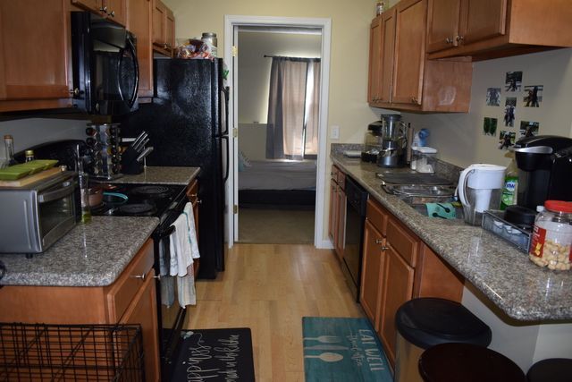 A kitchen with wooden cabinets and granite counter tops.