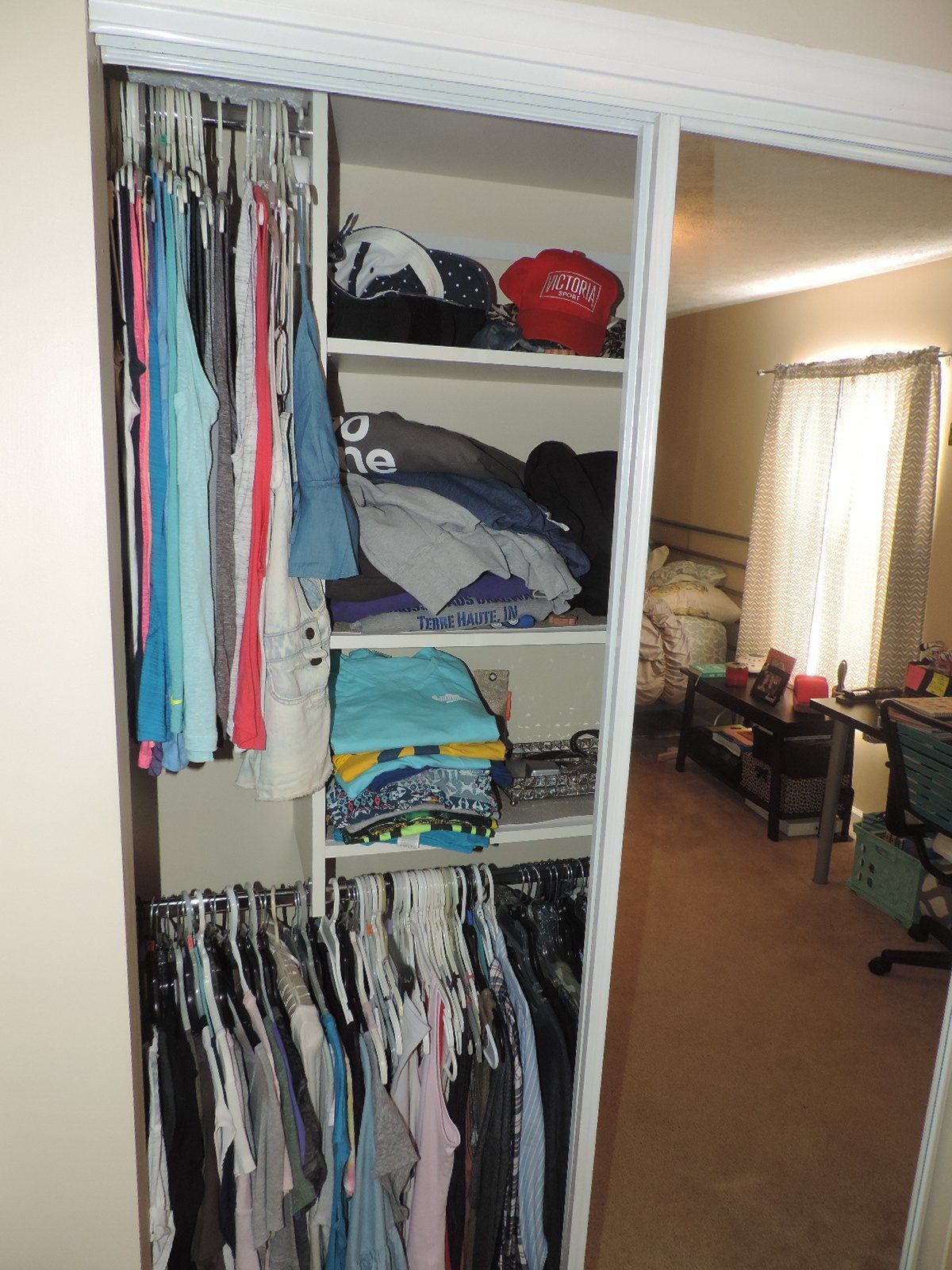 A closet filled with clothes and a mirror in a bedroom.