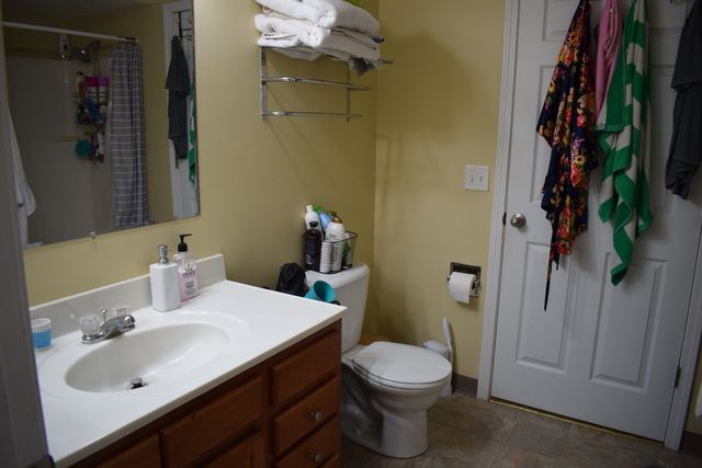 A bathroom with a sink, toilet, and mirror.