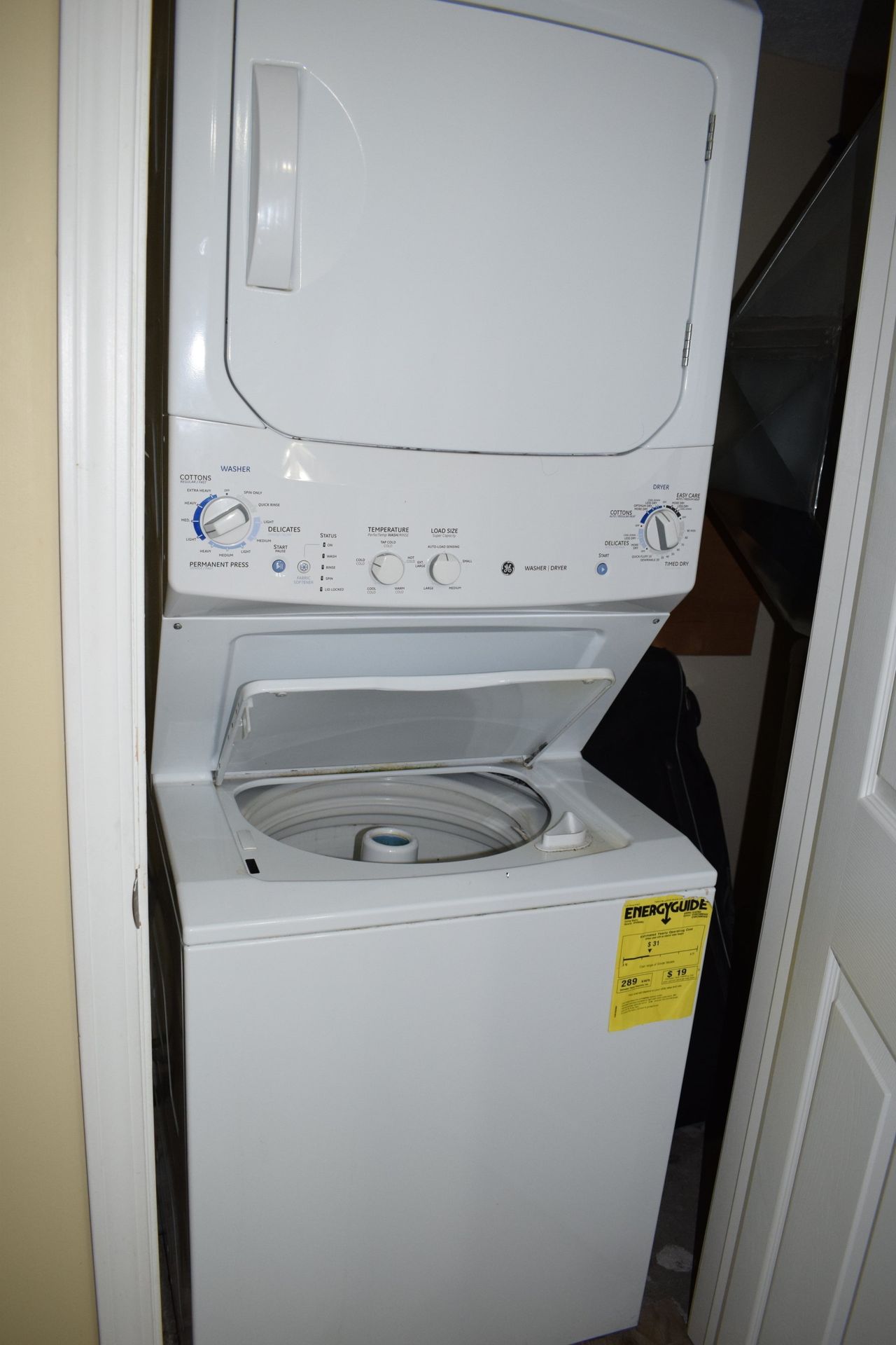 A washer and dryer are stacked on top of each other in a closet.