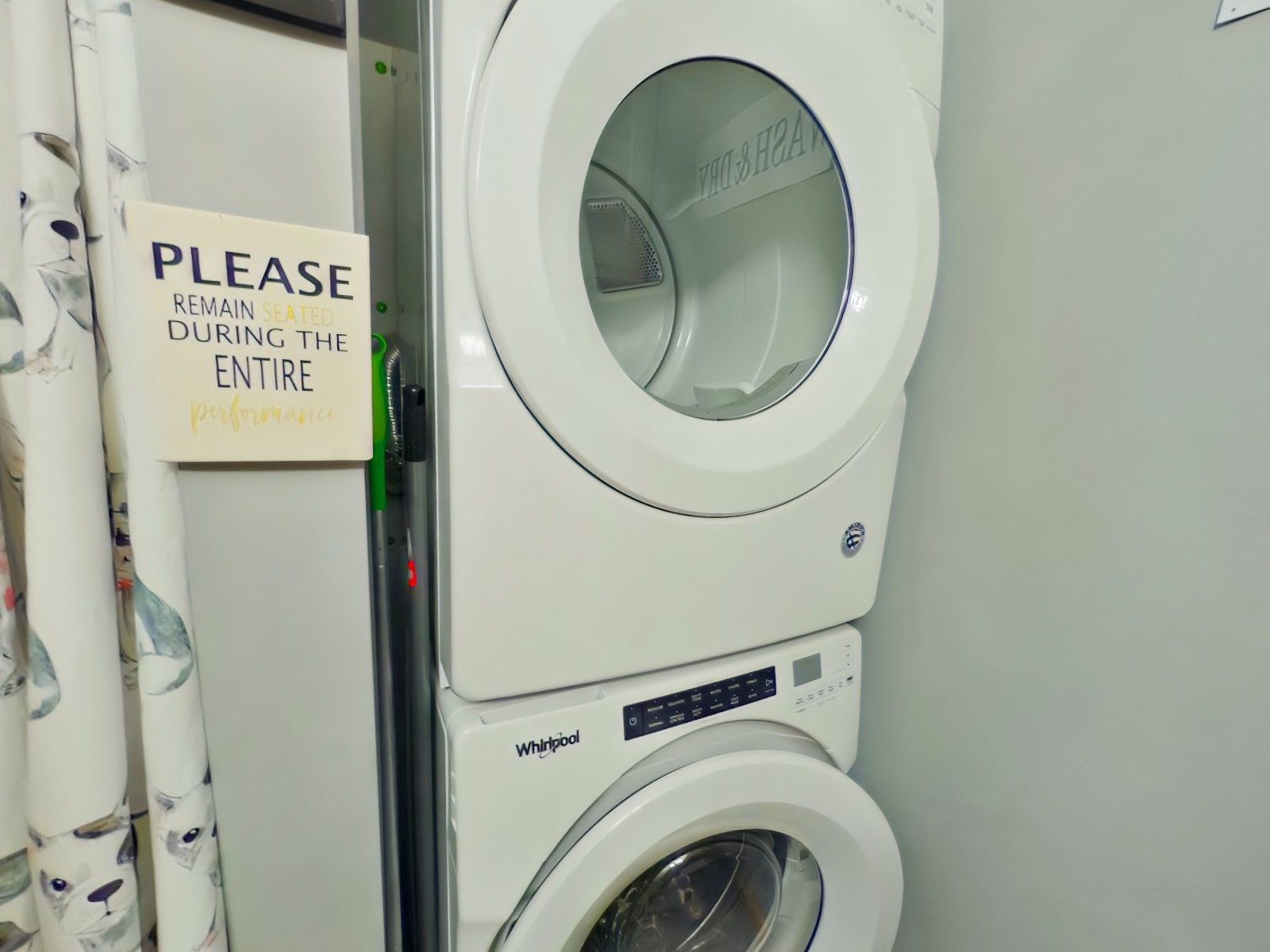 A washer and dryer are stacked on top of each other in a laundry room.