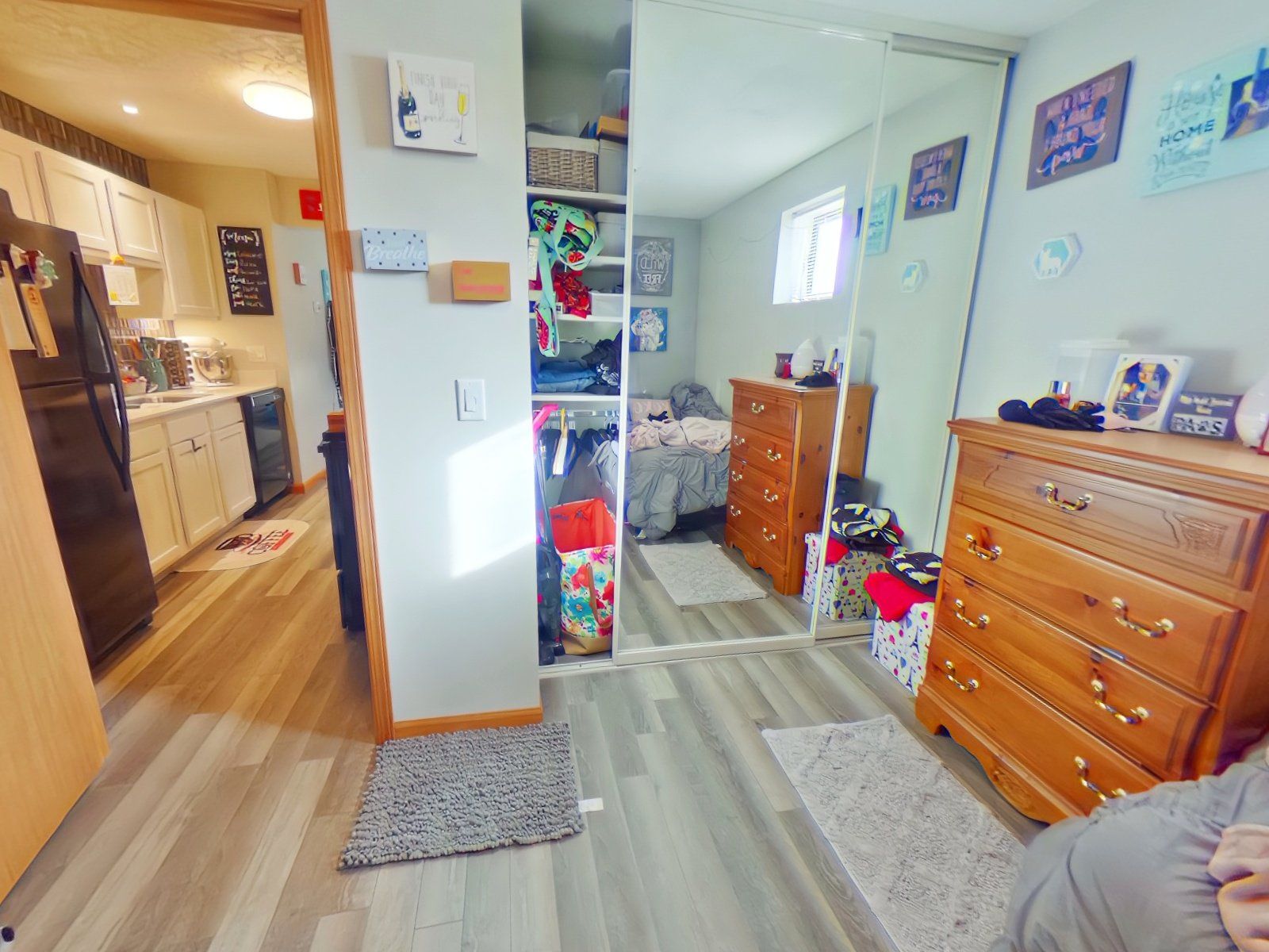 A bedroom with a bed, dresser, and mirror.