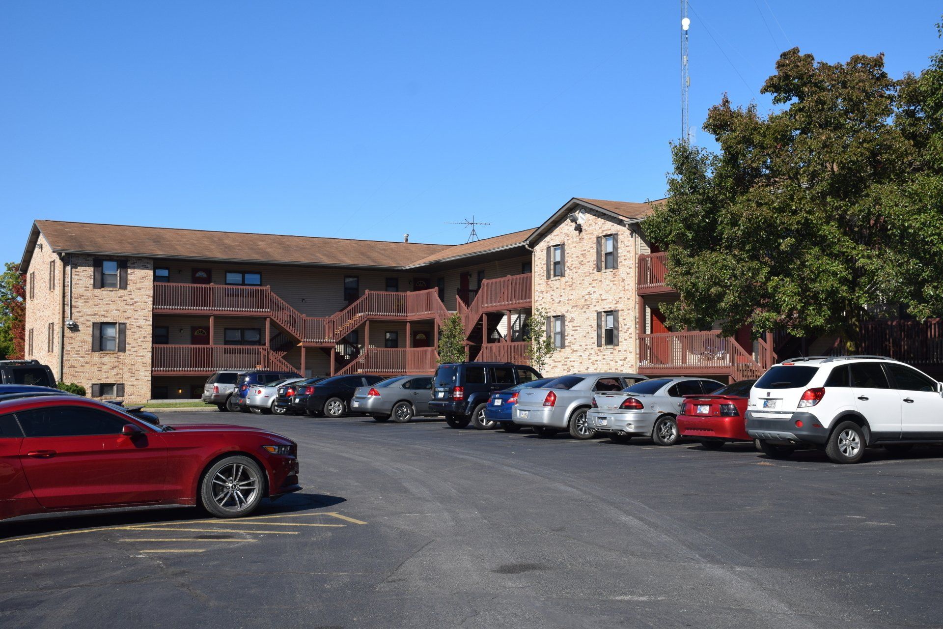 A row of cars are parked in front of a building.