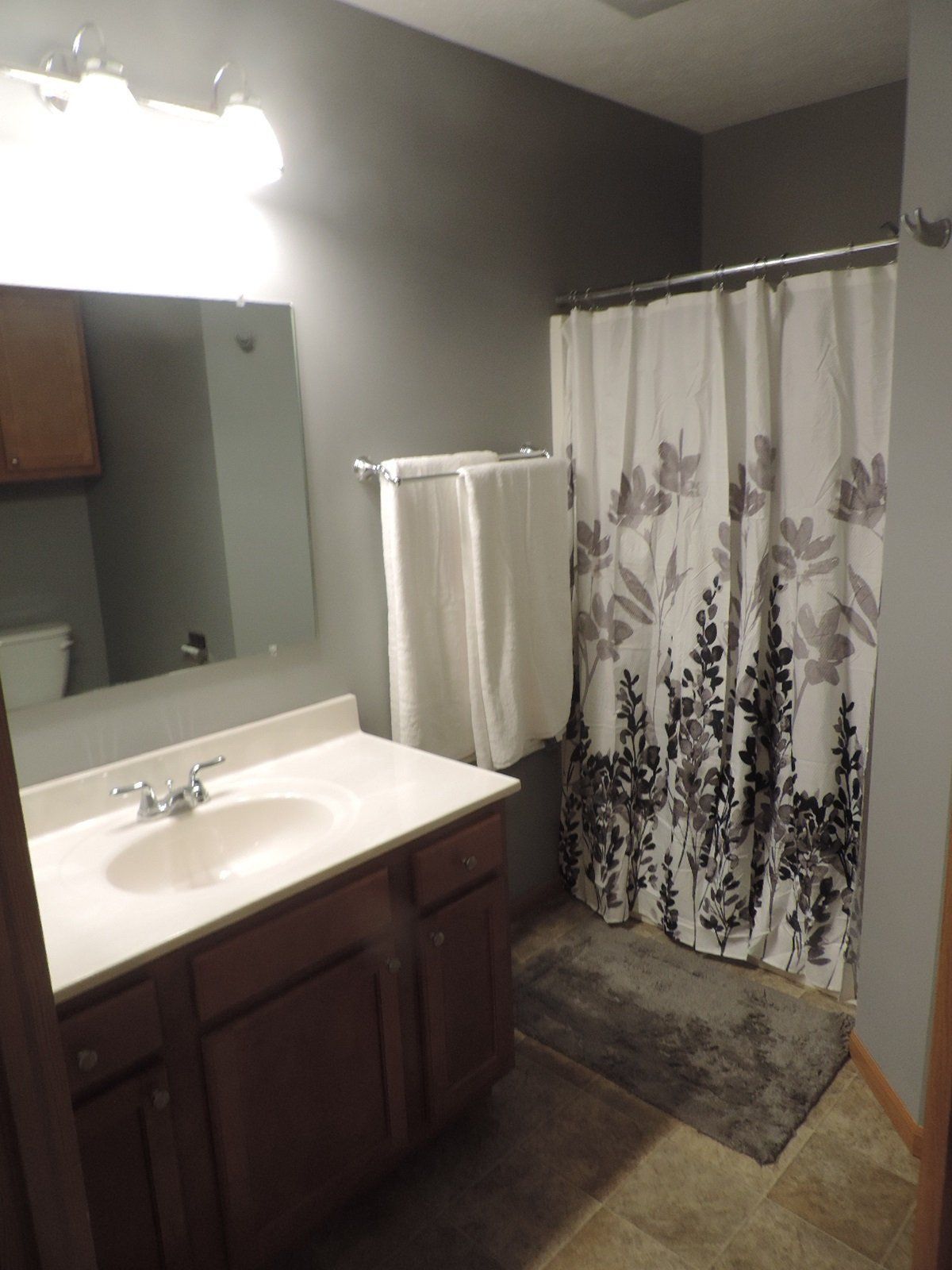 A bathroom with a sink and a shower curtain.