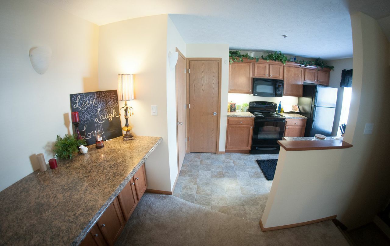 A kitchen with a stove, microwave, and cabinets.