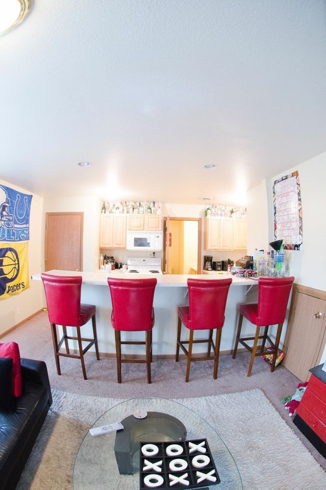 A kitchen and living room with red chairs