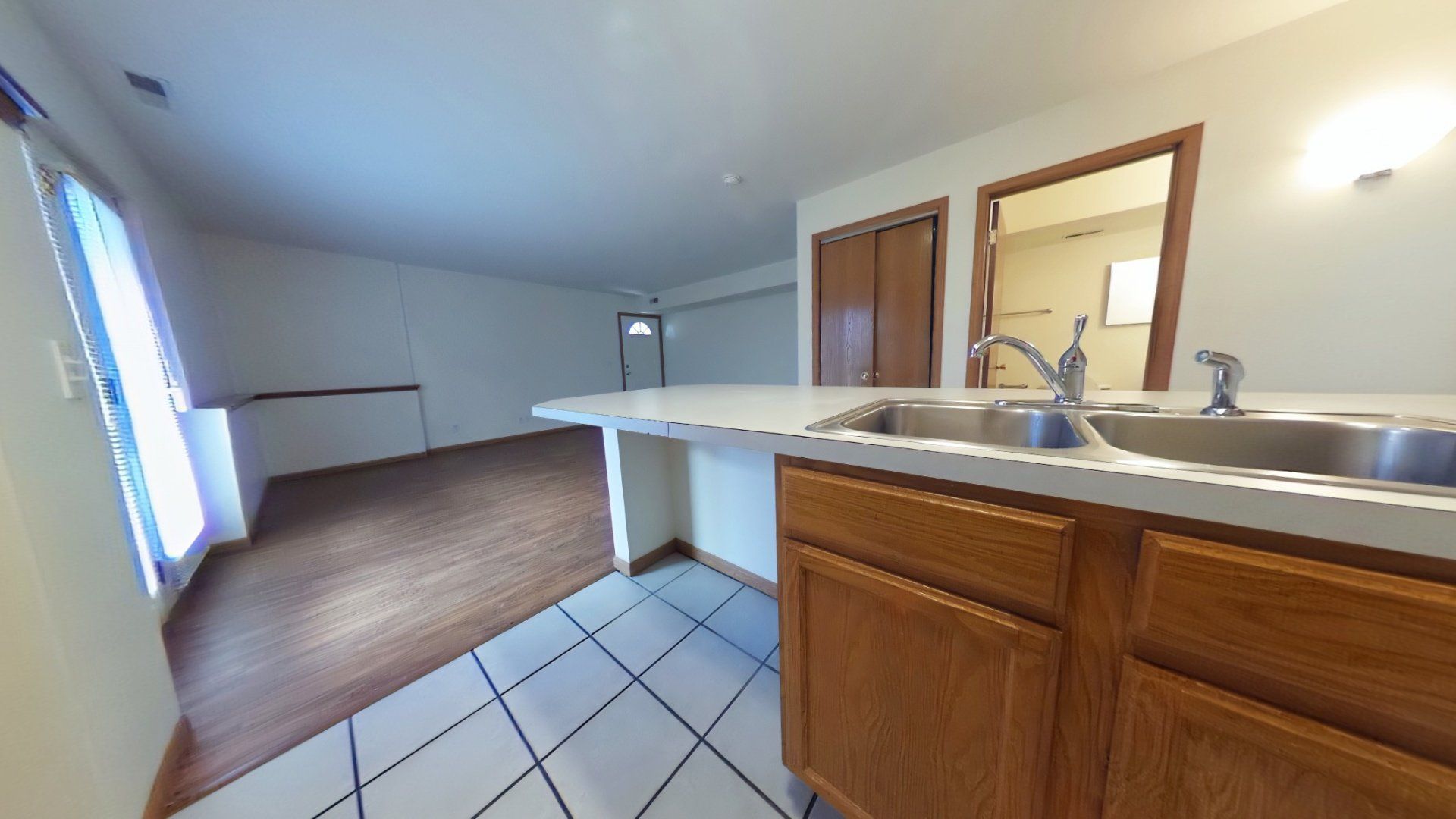 A kitchen with a sink and wooden cabinets.