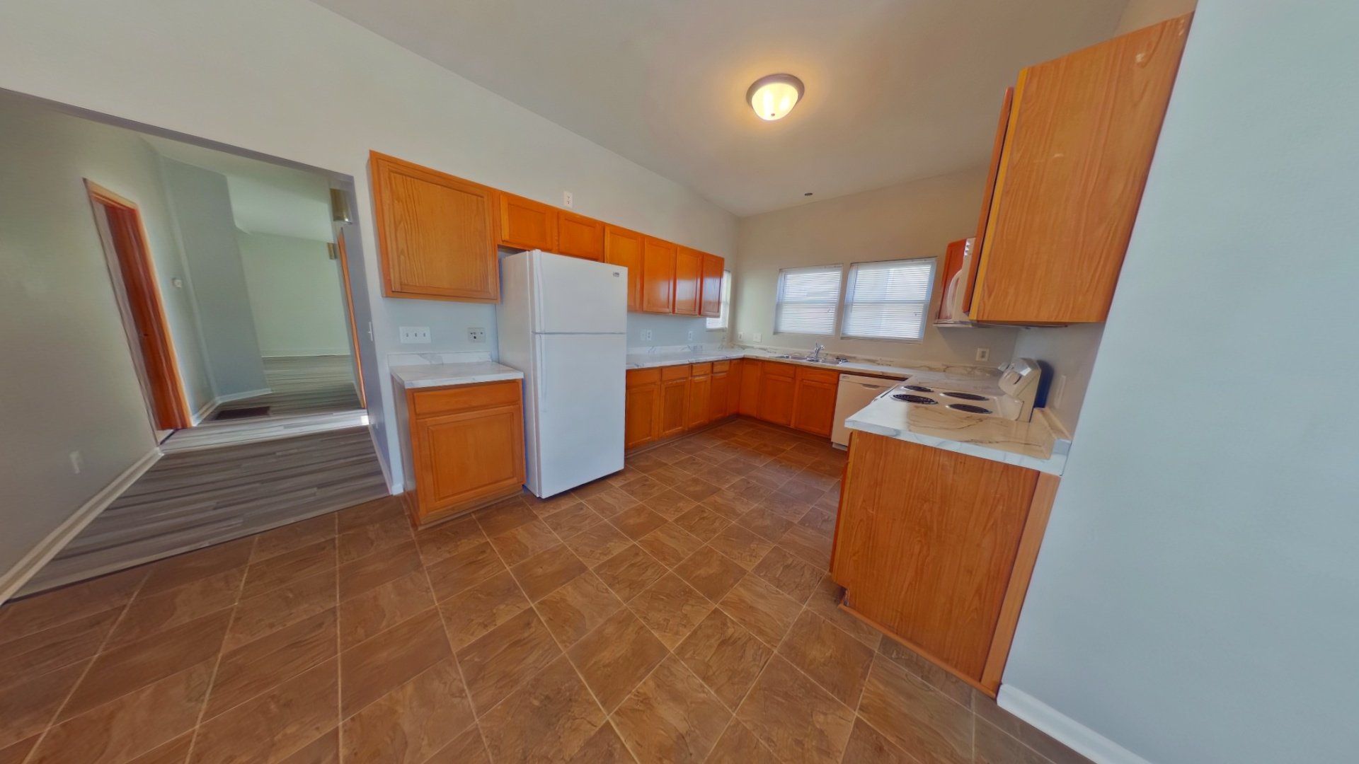 A kitchen with wooden cabinets and a white refrigerator.